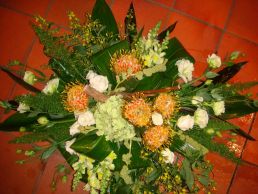 Stervormig uitvaartarrangement met witte lysianthus, aspidistrablad, gele leeuwenbek, hortensia, asparagus, amaranthus, tropische bloem