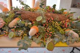 Kistversiering met papaver, boomschors, bessen, eucalyptus en banksia